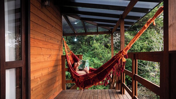 A wooden deck with a hammock and a book. - Tilli's Haus Praia & Campo (Florianópolis)