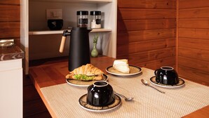 A breakfast setup with croissants, cheese, coffee, and tea on a wooden table. - Tilli's Haus Praia & Campo (Florianópolis)