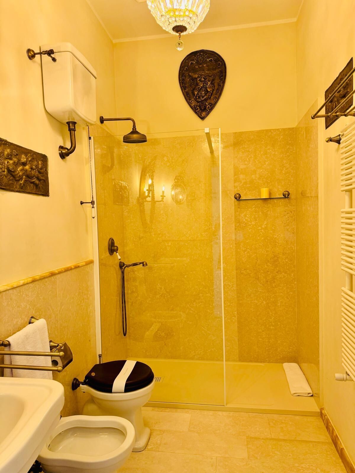 A bathroom with a glass shower enclosure, a toilet, and a sink.