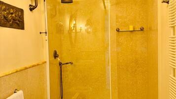 Une salle de bain avec une douche à parois de verre, des toilettes et un lavabo.