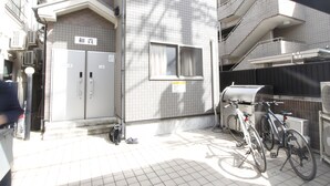 A residential building with a tiled exterior, a bicycle parked outside, and a visible staircase leading to an upper floor. - 205_Shinjuku Gourmet&Shopping Recently (新宿区)