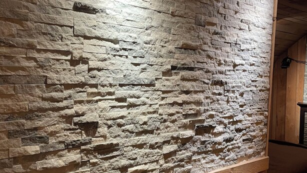 Un muro de piedra con diseño de paneles de madera.