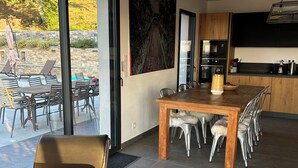 A modern kitchen with a dining area, large windows, and a view of the outdoors. - House with breathtaking views over the valley, only 15 minutes from Corte (Poggio-di-Venaco)