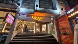 Une devanture de magasin avec une enseigne indiquant « Ginger » et une autre indiquant « Chambre disponible ».