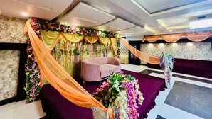 Une pièce avec un canapé rose, des étoffes drapées et des décorations florales.