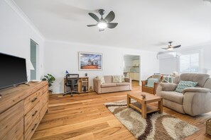 Relax in this stylish living room with a large flat-screen TV, comfortable sofa, and ample seating.