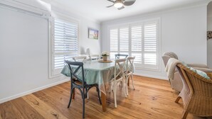 A dining area with a table, chairs, and a ceiling fan.