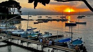 A marina with boats docked, a wooden pier, and a sunset in the background. - 2 Pièces Dans la Vieille Ville (Antibes)