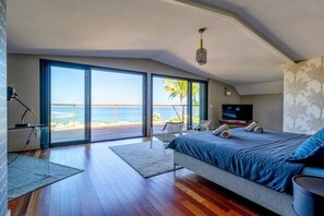 Una camera da letto con un letto grande, una televisione e vista sull'oceano.