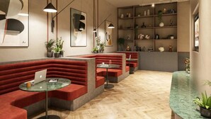 Een moderne zithoek met rode kussens, glazen tafels en diverse decoratieve objecten op planken.