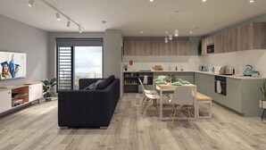 Een modern appartement met een woonkamer, een eethoek en een keuken.