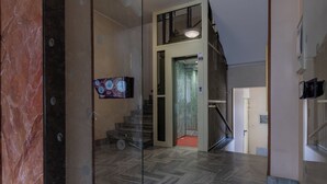 A modern interior with a herringbone-patterned floor, a staircase, and a glass partition. - CasaTo by Wonderful Italy (Turin)
