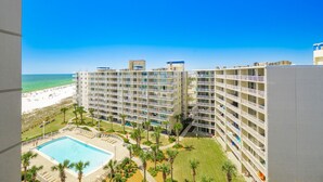 Un hotel de gran altura con múltiples balcones, piscina y vista a la playa.