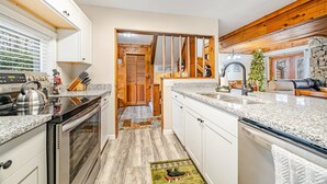 A modern kitchen with granite countertops, stainless steel appliances, and wooden accents. - 3 Bed, 2 Bath in Seven Springs Resort (Champion)