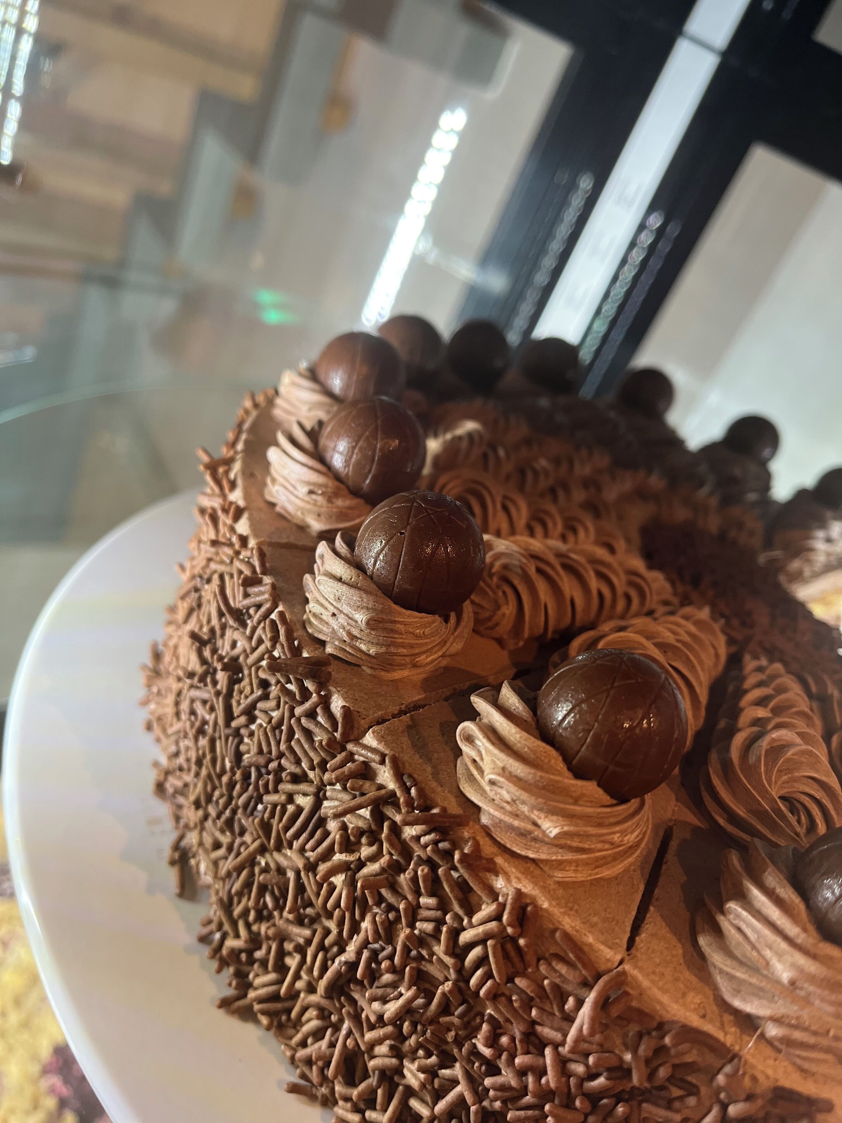 Un postre de chocolate con bolitas y grageas sobre un plato.