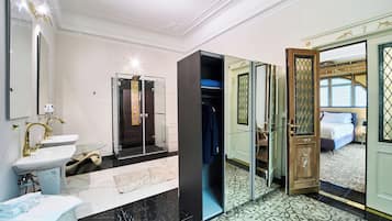 A modern bathroom with a sink, mirror, and shower.