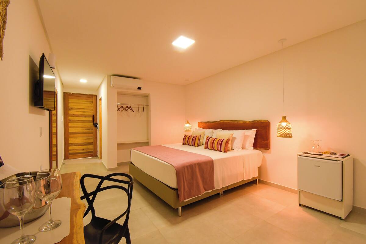 Un dormitorio con cama, mesita de noche y un pequeño refrigerador.