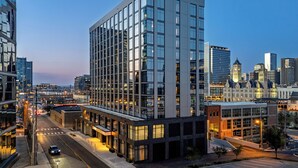 A modern hotel with a glass facade, located in a cityscape with other high-rise buildings. - Caption by Hyatt Downtown Nashville (Nashville)