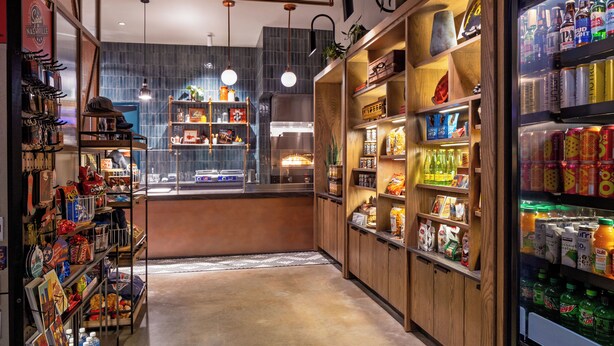 A well-lit, narrow corridor with shelves stocked with snacks, beverages, and souvenirs. - Caption by Hyatt Downtown Nashville (Nashville)