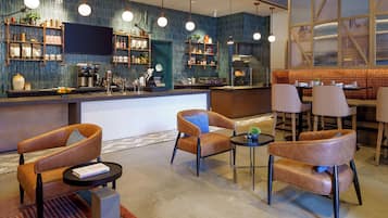 Een moderne bar met zitplaatsen, een balie en diverse voorzieningen.