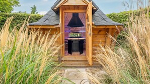A wooden cabin with a pitched roof, a central door, and a small porch area. - Seagate House, Brancaster, Norfolk (Brancaster)