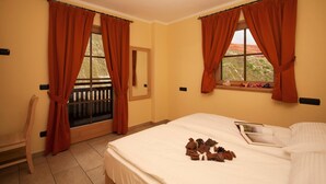 A hotel room with a bed, a window with curtains, a chair, and a view of the outdoors. - Sponda Ski in- Ski out Mt 50 (Livigno)