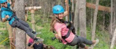 A zip-lining course with participants in safety gear.