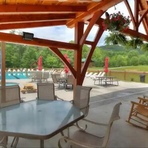 Eine Außenpatio mit Pool, Liegestühlen und einer Holz-Pergola.