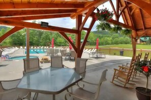 Eine Außenpatio mit Pool, Sitzbereich und einer Pergola aus Holz.