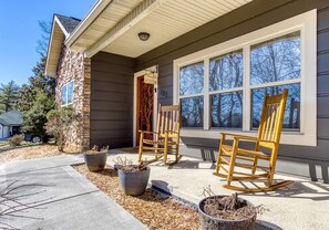 A house with a porch, two rocking chairs, and potted plants. - Irresistible Retreat w Pool Hot Tub Arcade (Sevierville)