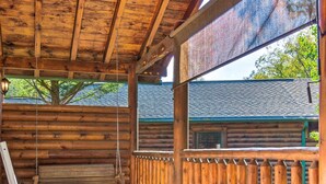 A wooden deck with a hot tub, wooden chairs, and a view of a house. - Dog Friendly Romantic Mtn Getaway Hot Tub Pool (Gatlinburg)