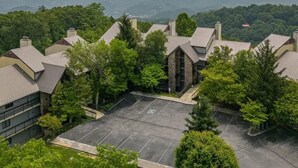 Une vue d’un quartier résidentiel avec plusieurs maisons, un parking et, au loin, un paysage montagneux.