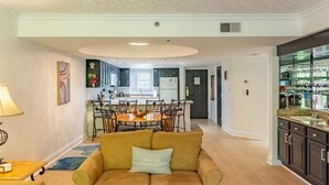 A living room with a sofa, coffee table, and a dining area with chairs and a table. - Luxurious Condo Pool Fireplace Hiking (Gatlinburg)