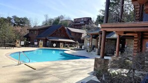 Area piscina con un edificio in legno sullo sfondo.