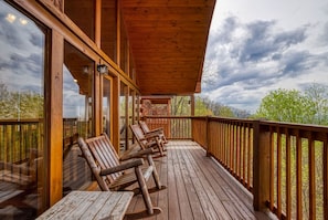 A wooden deck with benches and tables, overlooking a forested area. - Amazing Views Pool Hot Tub Pool Table Arcade (Sevierville)