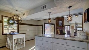A kitchen with a central island, white cabinetry, and pendant lighting. - New Luxury Remodel Fire Pit Game Room Hot Tub (Sevierville)