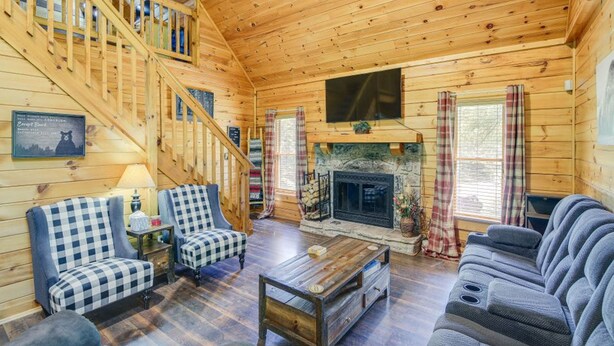 A cozy cabin interior with a wooden staircase, a fireplace, and a comfortable seating area. - 5-star w Pool Cozy Secluded Newly-renovated (Sevierville)