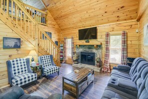 A cozy cabin interior with a wooden staircase, a fireplace, and a comfortable seating area. - 5-star w Pool Cozy Secluded Newly-renovated (Sevierville)