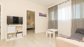 A modern living room with a flat-screen TV, a sofa, a small table, and a child’s playhouse. - Cabeceo in Jerez de la Frontera (Jerez de la Frontera)