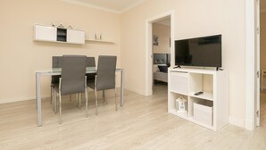A modern living room with a dining area, a flat-screen TV, and built-in storage. - Cabeceo in Jerez de la Frontera (Jerez de la Frontera)