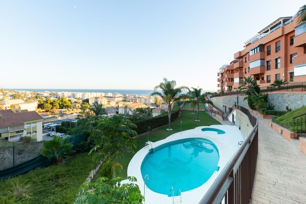 Ein Wohngebäude mit Swimmingpool, Stadtblick und blauem Himmel.