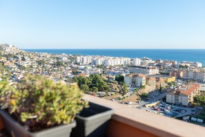 Eine Küstenstadt mit einer Mischung aus Wohn- und Geschäftsgebäuden, blauem Himmel und Blick aufs Meer.