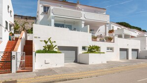A modern two-story building with a white facade, a covered outdoor area, and a staircase leading to the entrance. - Artola in Marbella With 4 Bedrooms and 3 Bathrooms (Marbella)