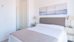 A neatly arranged bedroom with a bed, bedside tables, and a wall-mounted painting. - Artola in Marbella With 4 Bedrooms and 3 Bathrooms (Marbella)