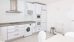 A modern kitchen with white cabinets, a stainless steel range hood, a built-in microwave, and a washing machine. - Artola in Marbella With 4 Bedrooms and 3 Bathrooms (Marbella)