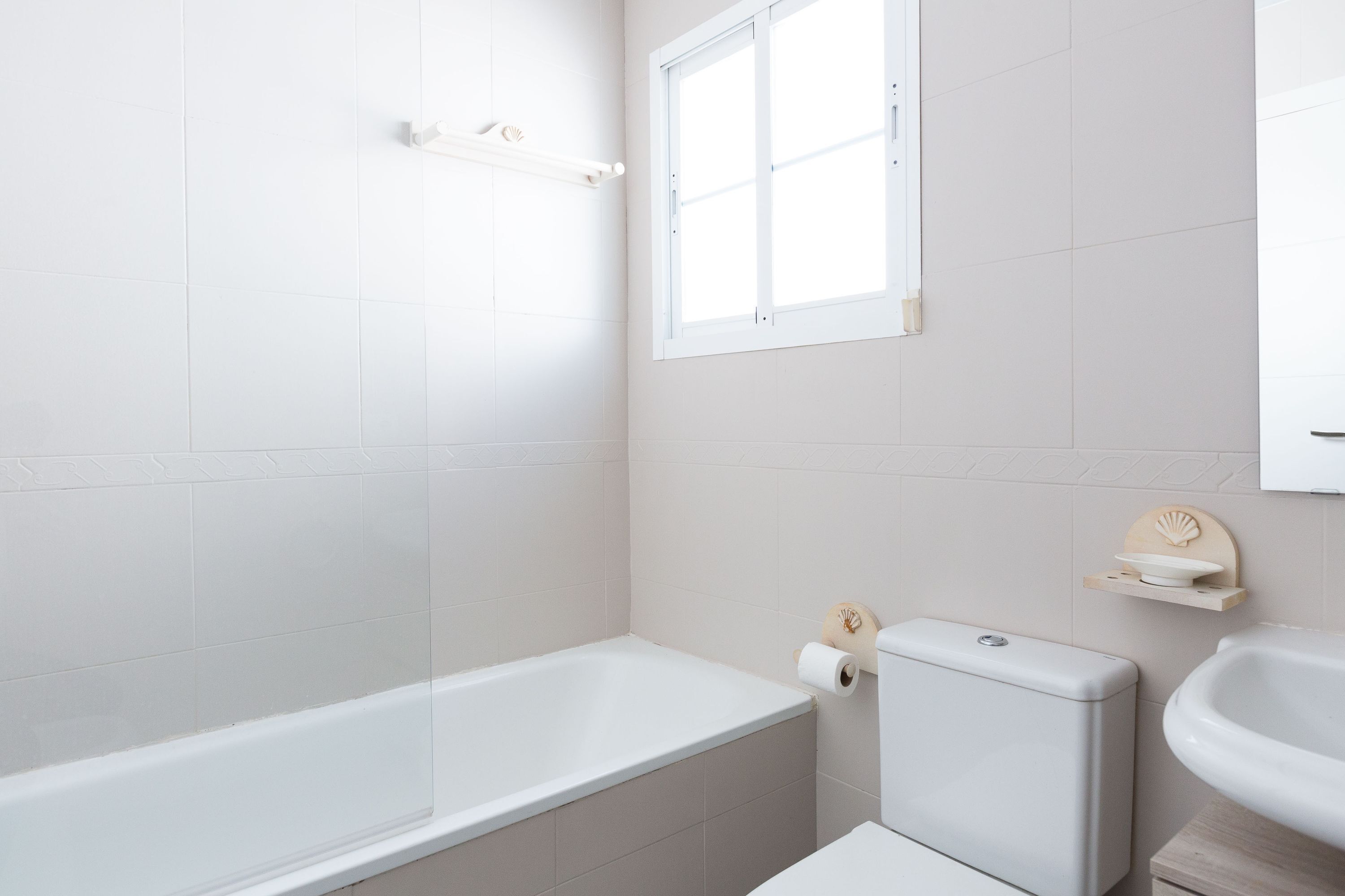 Et badeværelse med badekar, toilet og håndvask.