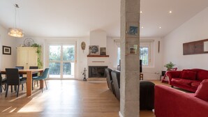 A spacious living area with a dining table, red sofa, and a fireplace. - Axarqu a in Malaga With 2 Bedrooms and 1 Bathrooms (Málaga)