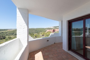 A balcony with a clear view of a hilly landscape and buildings in the distance. - Bahia Casares 4 in Casares (Casares)