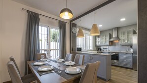A modern kitchen with grey cabinets, a central island, and pendant lighting. - Beautiful Duplex in Chiclana de la Frontera (Chiclana de la Frontera)