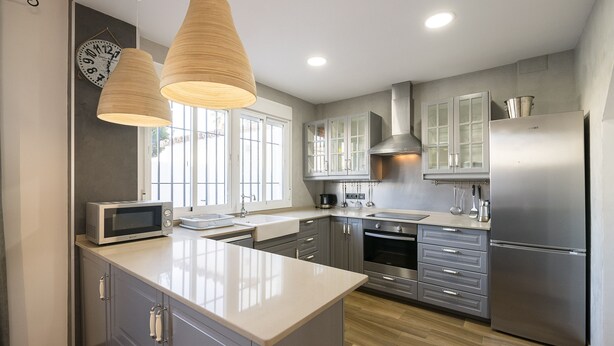 A modern kitchen with grey cabinets, stainless steel appliances, and a large island. - Beautiful Duplex in Chiclana de la Frontera (Chiclana de la Frontera)